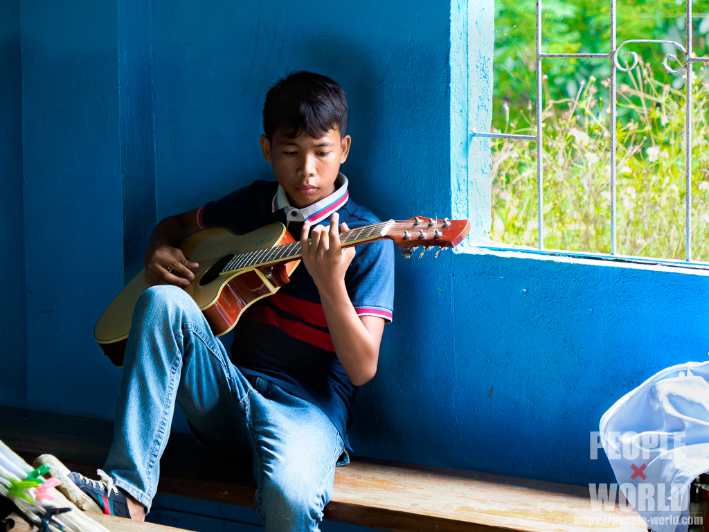 青い教会でギターを弾く少年（フィリピン）